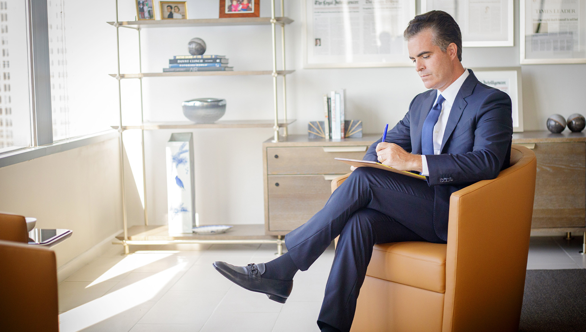 Ross Feller Casey founding partner Matt Casey seated in his office, writing notes on a legal pad