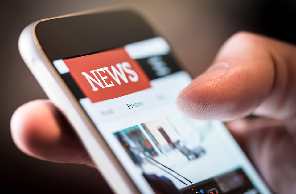 Person browsing news on a smartphone to find link building opportunities for law firm websites
